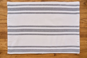 Detail showing Nordic grey striped fabric placemat on a brown wooden background