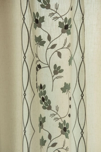 Detail of embroidered floral patterns and linen texture on semi-sheer curtains