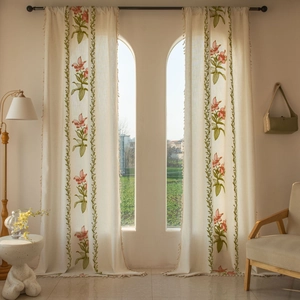 Dettaglio di tende beige con ricamo di gigli rossi ed eleganti frange con nappe