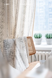 Detail of French vintage curtains and matching table runner with grey geometric patterns