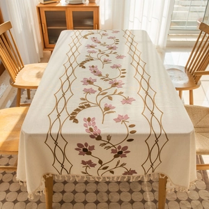 Detail of floral embroidery and elegant tassel fringe on a rectangular cotton linen tablecloth