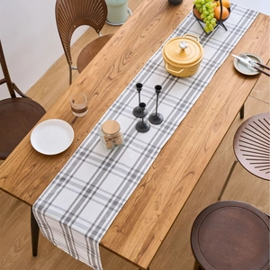 Modern Nordic table runner featuring grey and white check pattern on a wooden surface