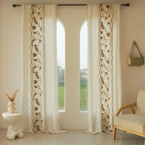 Detailed floral embroidery and tassel fringe on beige semi-sheer cotton linen curtains