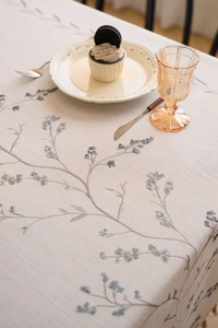 Detailed view of lilac branch embroidery on beige cotton linen rectangular tablecloth