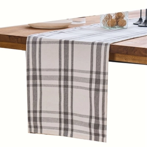 Modern grey and white checkered table runner on a wooden dining table setup