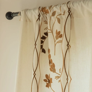 Close-up of beige linen curtain with flower embroidery and geometric diamond patterns