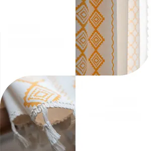 Close-up of yellow geometric print beige curtain with woven tassel edge details