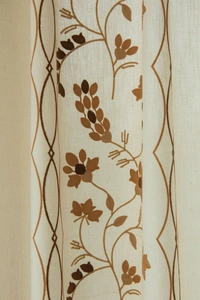 Detail of floral embroidery and geometric patterns on semi-sheer beige cotton linen curtain
