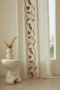 Detail of floral embroidery and fringe tassels on semi-sheer linen cotton curtains