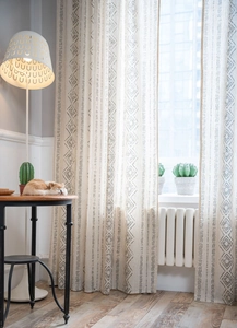 Close-up of French vintage linen curtains with grey geometric patterns and boho design