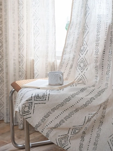 Close-up of French retro curtain fabric with black geometric prints and linen texture