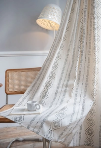 Detail of bohemian geometric print curtain fabric with thick cotton linen texture and drape