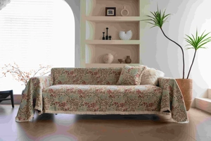 Detailed close-up of pink floral jacquard sofa cover with cotton fringe tassels