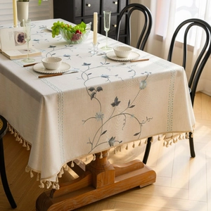 Linen cotton tablecloth with blue floral embroidery and beige fringe tassels for dining table