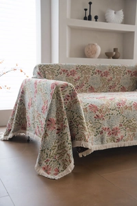 Detailed close-up of thick woven fabric with pink floral patterns and white fringe edges
