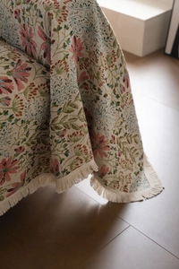Close-up of floral jacquard sofa throw with elegant tassels and thick woven texture