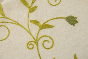 Macro detail of leaf embroidery on beige cotton linen fabric with high texture