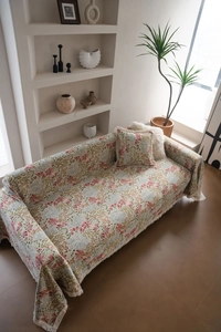 Floral jacquard sofa cover with pink blossoms and elegant tassels in a cozy home setting
