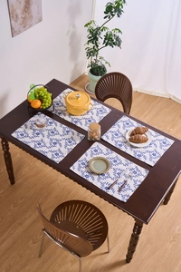 Detalle de manteles individuales florales en una mesa de madera en comedor acogedor