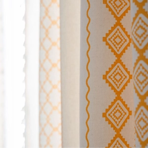 Beige curtain with yellow geometric pattern and tassels in a boho chic home decor style