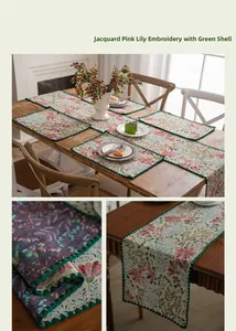 Detail of floral jacquard table runner with pink lily embroidery and green scalloped edges