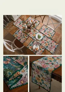 Close-up of jacquard table runner fabric with colorful floral patterns and green scalloped edges