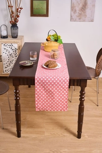 Pink heart print table runner on dark wood dining table in cozy home setting