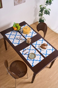 Detalle de manteles individuales de algodón y lino con patrón marroquí azul sobre madera