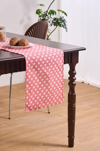 Pink heart print fabric table runner on a dark wood dining table for home decor