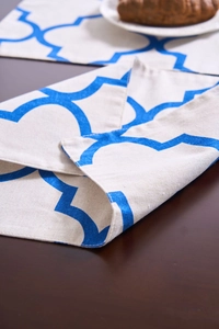 Detalle de un patrón geométrico azul marroquí en un mantel individual blanco