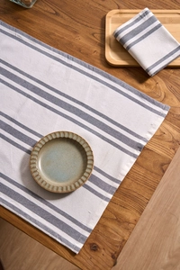 Detail of gray striped cotton linen napkin showing hemmed edges and woven fabric texture