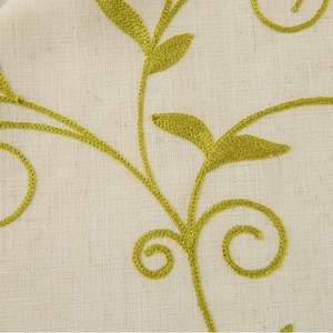 Beige cotton linen curtain featuring delicate green floral vine embroidery and tassels