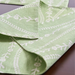 Tovaglietta verde in lino con motivi floreali bianchi e texture geometriche