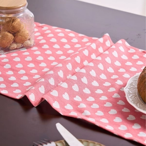Pink table runner with white heart prints on woven cotton fabric for home decor