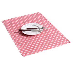 Pink cloth napkin with white heart patterns paired with white plate and cutlery set