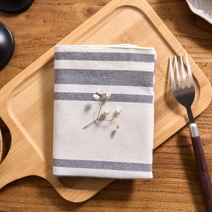 Nordic style grey and white striped linen napkin displayed on wooden board with dry flowers