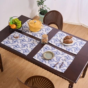 Juego de 4 manteles individuales con estampado de flores sobre mesa de madera