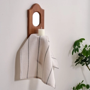 Japanese style black and white striped linen napkin hanging on a vintage wooden wall mirror