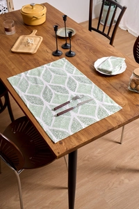 Detail of Nordic green leaf print fabric napkin and placemat set on a wooden table