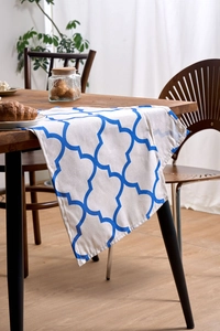 Detail showing the blue quatrefoil geometric pattern and durable linen texture on the runner