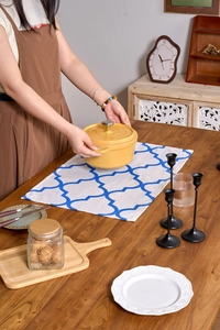 Yellow cast iron enamel pot with silver handle on a cozy rustic dining table