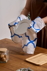 Close-up of blue geometric printed linen napkin holding a ceramic plate on wooden table