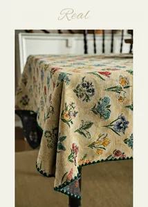 Detail of floral jacquard tablecloth featuring vintage garden patterns and dark green scalloped edges