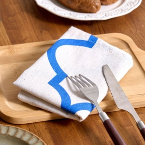 Blue geometric print cloth napkin on wooden tray with cutlery for modern dining decor