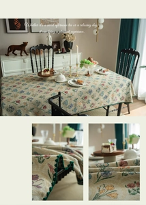 Detailed view of French vintage floral jacquard tablecloth with dark green scalloped edges