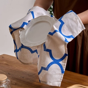 Blue geometric print oven mitt pad on wooden table with warm home kitchen atmosphere