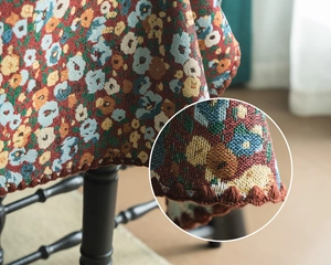 Detail of vintage floral jacquard tablecloth with deep red crochet tassel edges