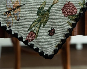Close-up of jacquard table runner with dragonfly and tulip embroidery details