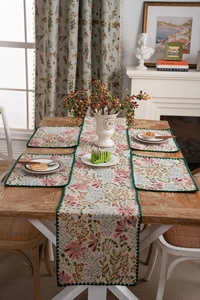 Floral table runner set with embroidered lily patterns and dark green woven edges