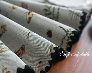 Detailed macro view of soft embroidered floral table runner with elegant black wavy lace edges